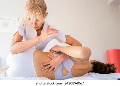 Female osteopath rubbing back of patient - Powered by Shutterstock