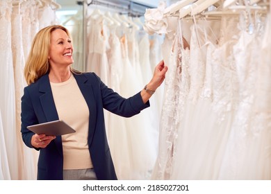 Female Owner Of Bridal Wedding Dress Shop With Digital Tablet