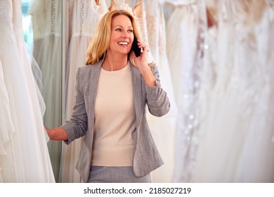 Female Owner Of Bridal Wedding Dress Shop Talking On Mobile Phone