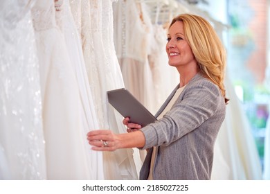 Female Owner Of Bridal Wedding Dress Shop With Digital Tablet