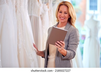 Female Owner Of Bridal Wedding Dress Shop With Digital Tablet