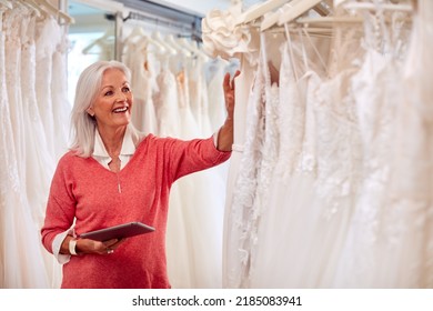 Female Owner Of Bridal Wedding Dress Shop With Digital Tablet