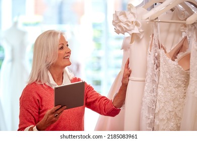 Female Owner Of Bridal Wedding Dress Shop With Digital Tablet