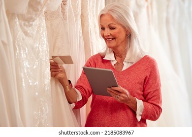 Female Owner Of Bridal Wedding Dress Shop With Digital Tablet