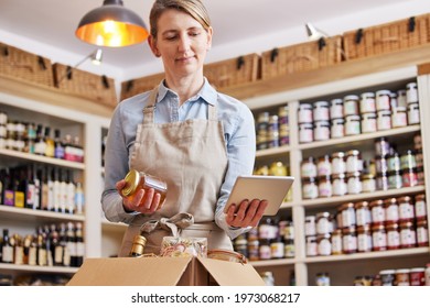 Female Owner Of Delicatessen Food Shop With Digital Tablet Preparing Online Grocery Order - Shutterstock ID 1973068217