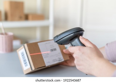 Female Owner Of Start Up Small Business Using Barcode Scanner Scanning Retail Drop Shipping Package Postal Parcel Bar Code. Warehouse Worker. 