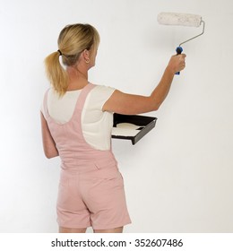 Female Painter Decorator Using A Paint Roller