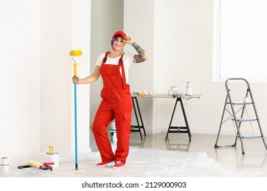 Female painter with red uniform and paint roller in room