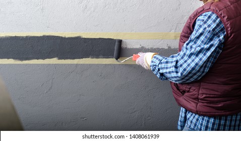 female painting a wall with masking tape and roller - Powered by Shutterstock