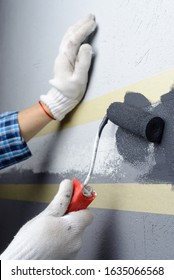 Female Painting A Wall With Masking Tape And Roller