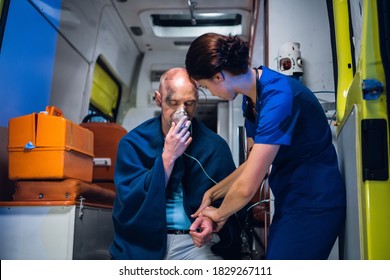 A female paramedic providing first aid to an injured man resqued from the fire, checking his pulse. - Powered by Shutterstock