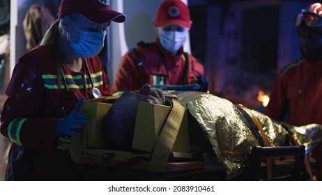 Female Paramedic Speaking To Male Survivor