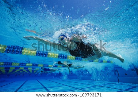 Female participants gushing through water in swimming competition
