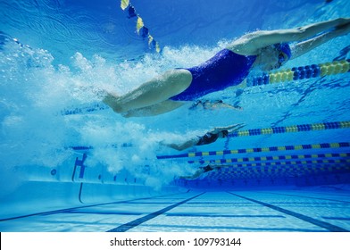 Female participants swimming underwater during a swimming race