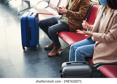 Female passenger using hand sanitizer at airport - Shutterstock ID 1987632071