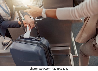 Female passenger weighing luggage at airport check in - Powered by Shutterstock