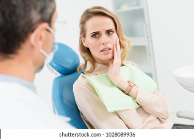 Female patient concerned about toothache in modern dental clinic