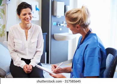 Female Patient And Doctor Have Consultation In Hospital Room