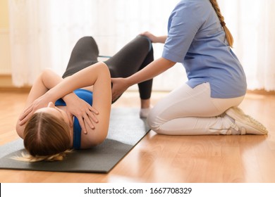 Female patient exercising with her physiotherapist using resistance band. Physical therapy concept. - Powered by Shutterstock