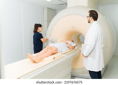 Female patient getting a medical test at the hospital and doing a magnetic resonance to check for cancer with a doctor and radiologist