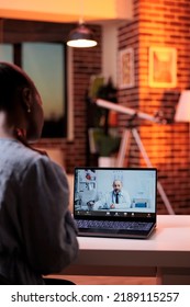 Female Patient Having Online Consultation With Doctor, Telehealth Service Concept. African American Woman Talking With General Practitioner On Videocall In Room With Beautiful Warm Sunset Light