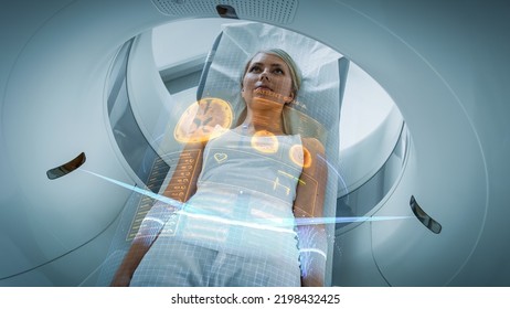 Female Patient Lying on a CT or PET or MRI Scan Bed, Moving Inside the Machine While it Scans Her Brain and Vital Parameters. AR Concept with Visual Effects In the Lab with High-Tech Equipment. - Shutterstock ID 2198432425