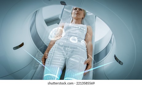 Female Patient Lying on a CT or PET or MRI Scan, Moving Inside the Machine While it Scans Her Brain and Vital Parameters. AR Concept of Visual Effects In Medical Lab, High-Tech Hospital.