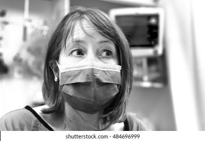 Female Patient In Mask Recovering After Surgery In Post Operative Care Room In Modern Hospital. High Key Image.