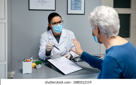 Female patient refusing to sign consent form for coronavirus vaccine - Shutterstock ID 1880312119