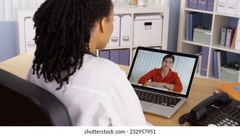 Female Patient Talking To African American Doctor Over Video Chat