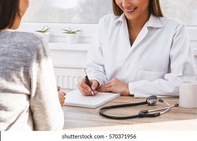 Female Patient Tells The Doctor About Her Health Complaints. Teen Girl Having Consultation With Beautiful Female Doctor.