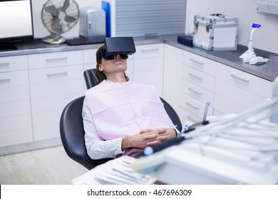 Female patient using virtual reality headset during a dental visit at dental clinic - Powered by Shutterstock