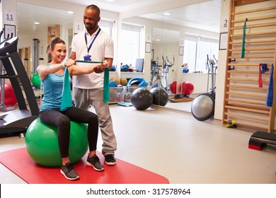 Female Patient Working With Physiotherapist In Hospital