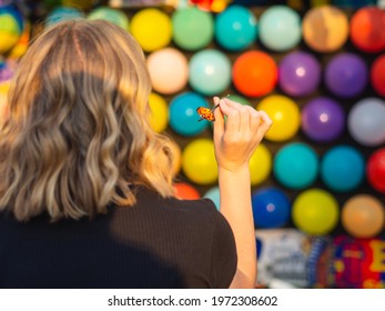 A Female Paying Shooting Range With Colorful Balloons At The Amusement Par