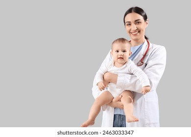 Female pediatrician with little baby on light background - Powered by Shutterstock