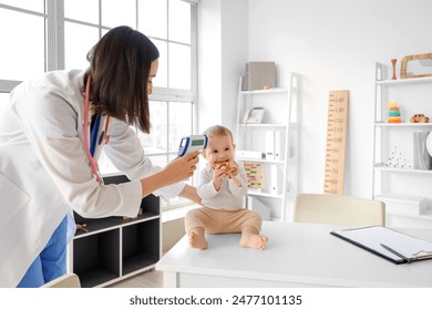 Female pediatrician measuring temperature of little baby in clinic - Powered by Shutterstock