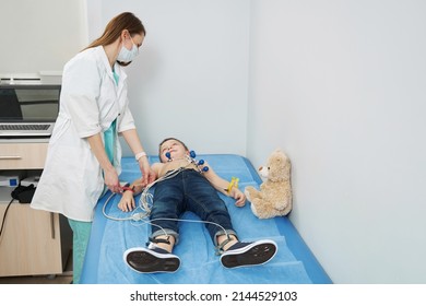 Female Pediatrician Performing Electrocardiogram Test In Clinic