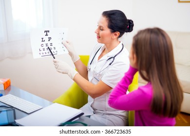 Female Pediatrician Pointing At Eye Chart To Child