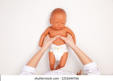 Female pediatrician showing manual chest compressions technique on a CPR dummy during infant first aid training. Cardiopulmonary resuscitation practise - Powered by Shutterstock