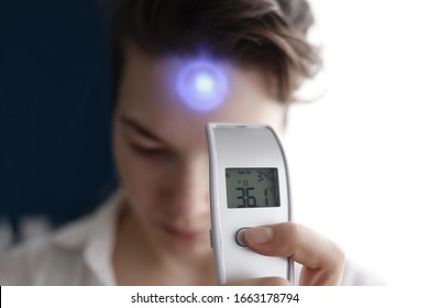 A female person being measured body temperature with a contactless thermometer - Shutterstock ID 1663178794