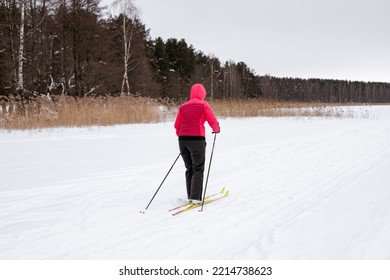 Female Person Exercising Cross-country Skiing On The Frozen Lake Ice Sheet In Winter Day.Active People Outdoors. Scenic Peaceful Finnish Landscape