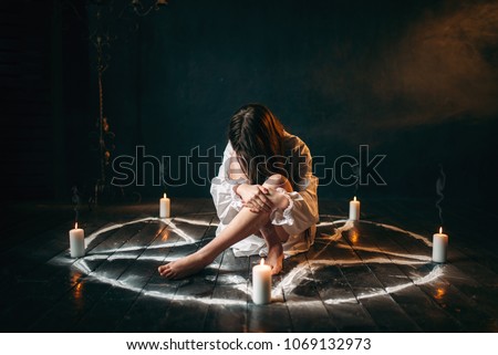 Female person sitting in pentagram circle, magic