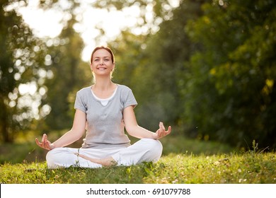 Female person in yoga pose in sunny nature