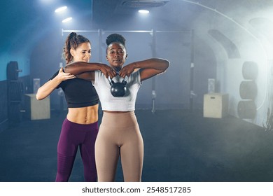 Female personal trainer assisting client lifting kettlebell during workout in gym - Powered by Shutterstock