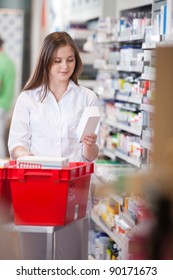 Female Pharmacist In Drugstore Stocking Shelves