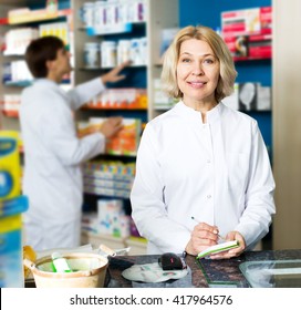 Female Pharmacist And Male Pharmacy Technician Posing In Pharmacy