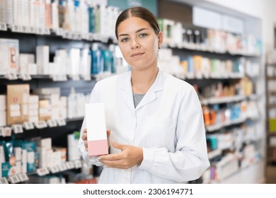 Female pharmacist offers cosmetics products while standing in the trading floor of a pharmacy - Powered by Shutterstock