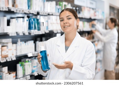 Female pharmacist offers cosmetics products while standing in the trading floor of a pharmacy - Powered by Shutterstock