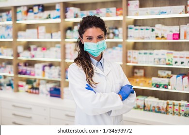 Female pharmacist with protective mask on her face working at pharmacy. Medical healthcare concept. - Shutterstock ID 1734593972