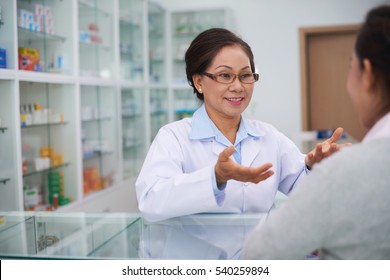 Female Pharmacist Talking To Drugstore Customer